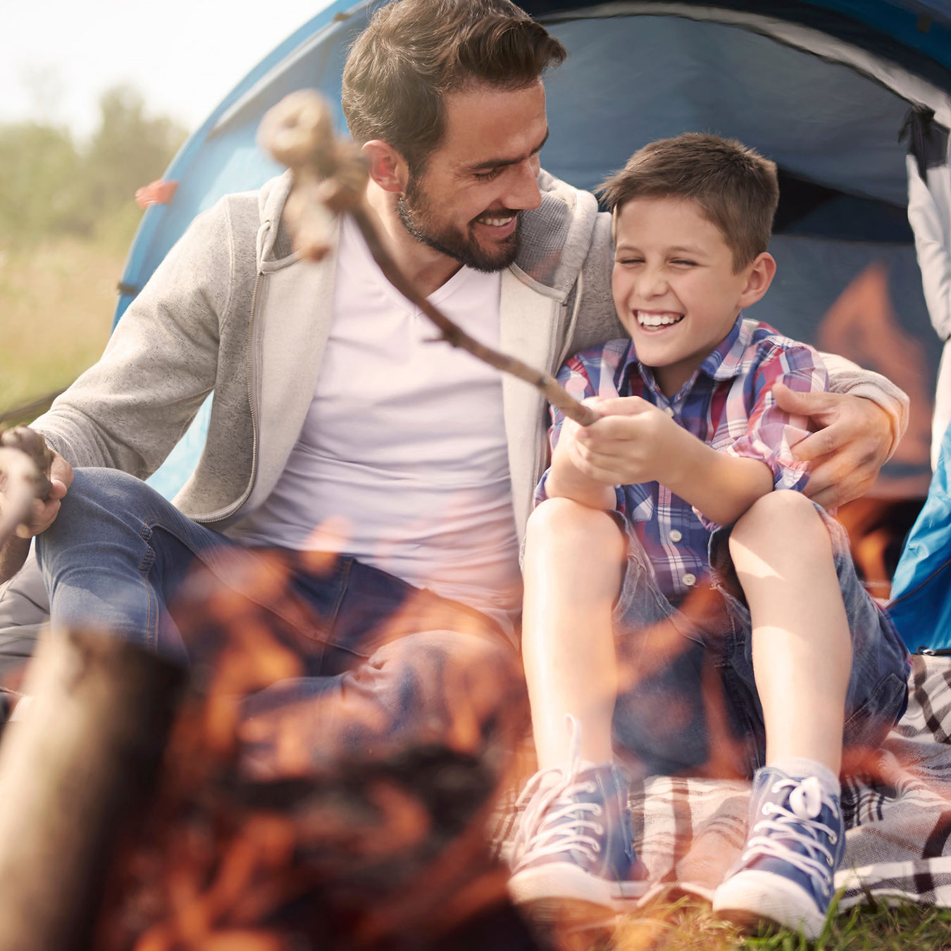 Father and son using a camp fire